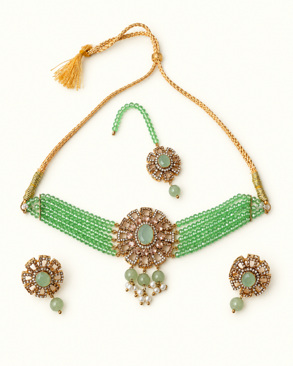 Green beaded necklace set with gold-plated metal details, featuring a choker necklace, matching earrings, and a maang tikka, arranged on a plain white background.
