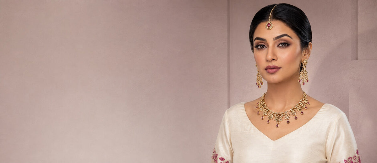 Pakistani woman wearing a gold and magenta zircon necklace set with earrings and tikka from Zurein